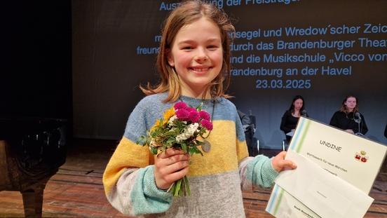 Mavie Eckert mit Siegerurkunde und Blumen